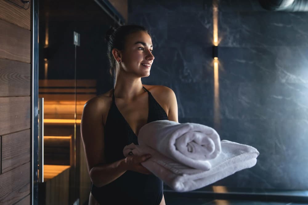 Mujer en sauna con toallas